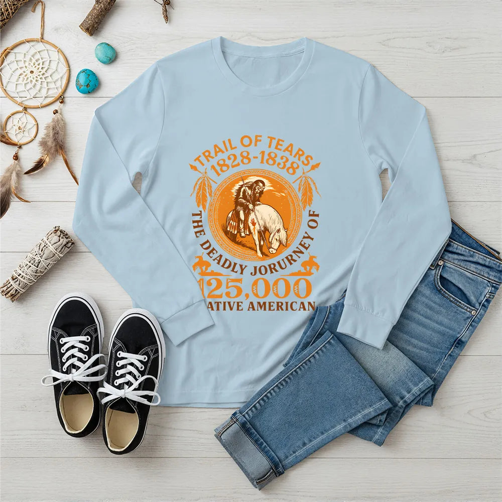 A light blue long-sleeve t-shirt featuring the "Trail of Tears" graphic, presented with jeans and casual shoes.