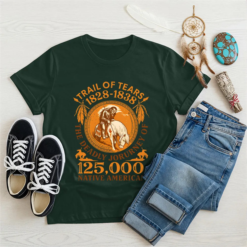 A forest green t-shirt with the "Trail of Tears" commemorative print, arranged with a dreamcatcher and turquoise stones.