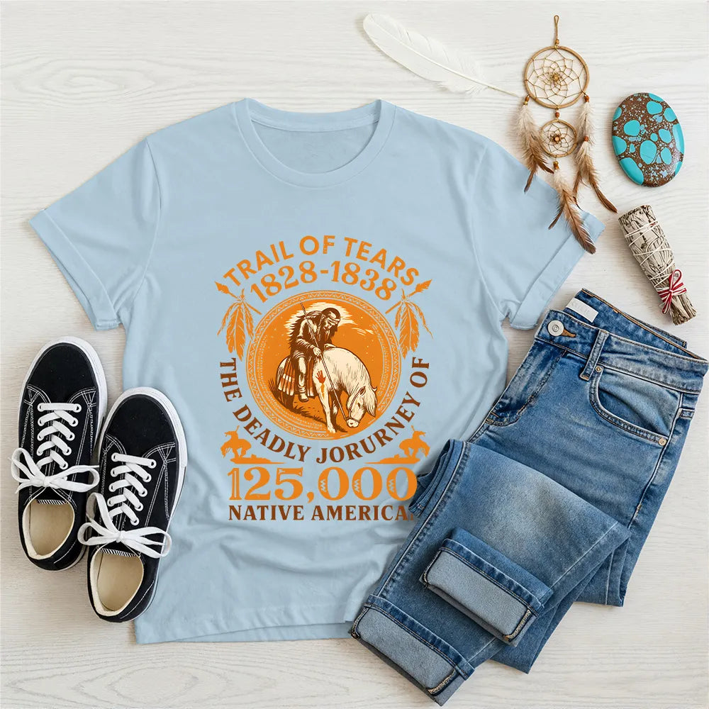 A light blue t-shirt featuring the "Trail of Tears" graphic, presented with a dreamcatcher and sage bundle.