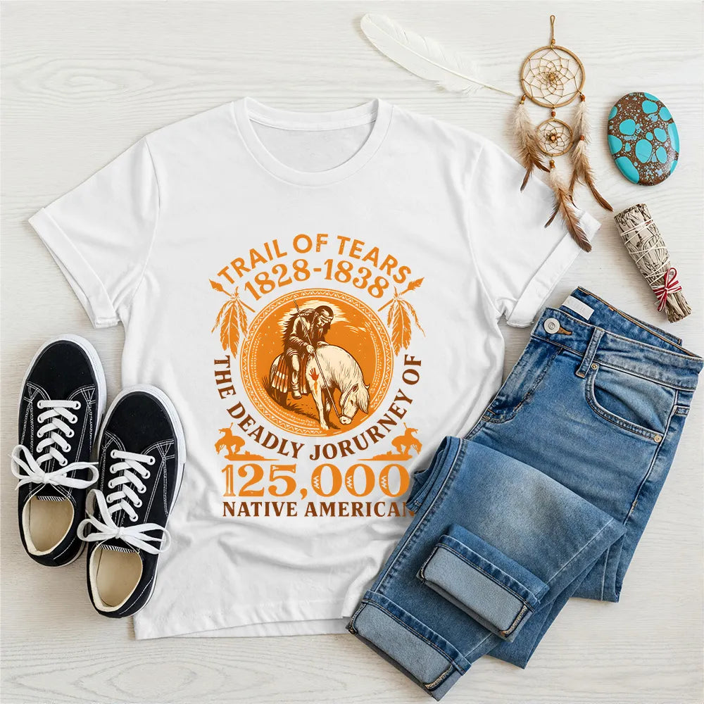 A white t-shirt featuring the "Trail of Tears 1828-1838 The Deadly Journey of 125,000 Native American" graphic in orange, styled with jeans and black sneakers.