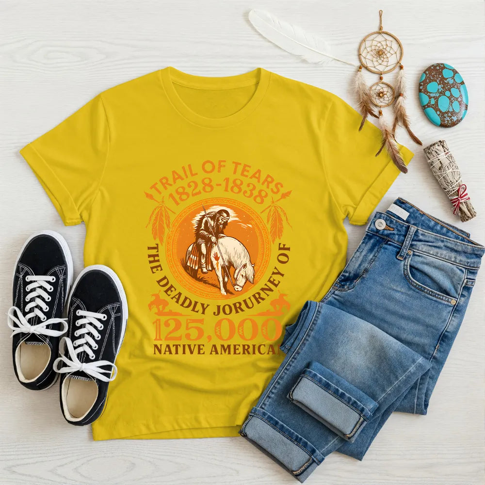 A yellow t-shirt with the "Trail of Tears" graphic in a flat lay, surrounded by Native American inspired items.