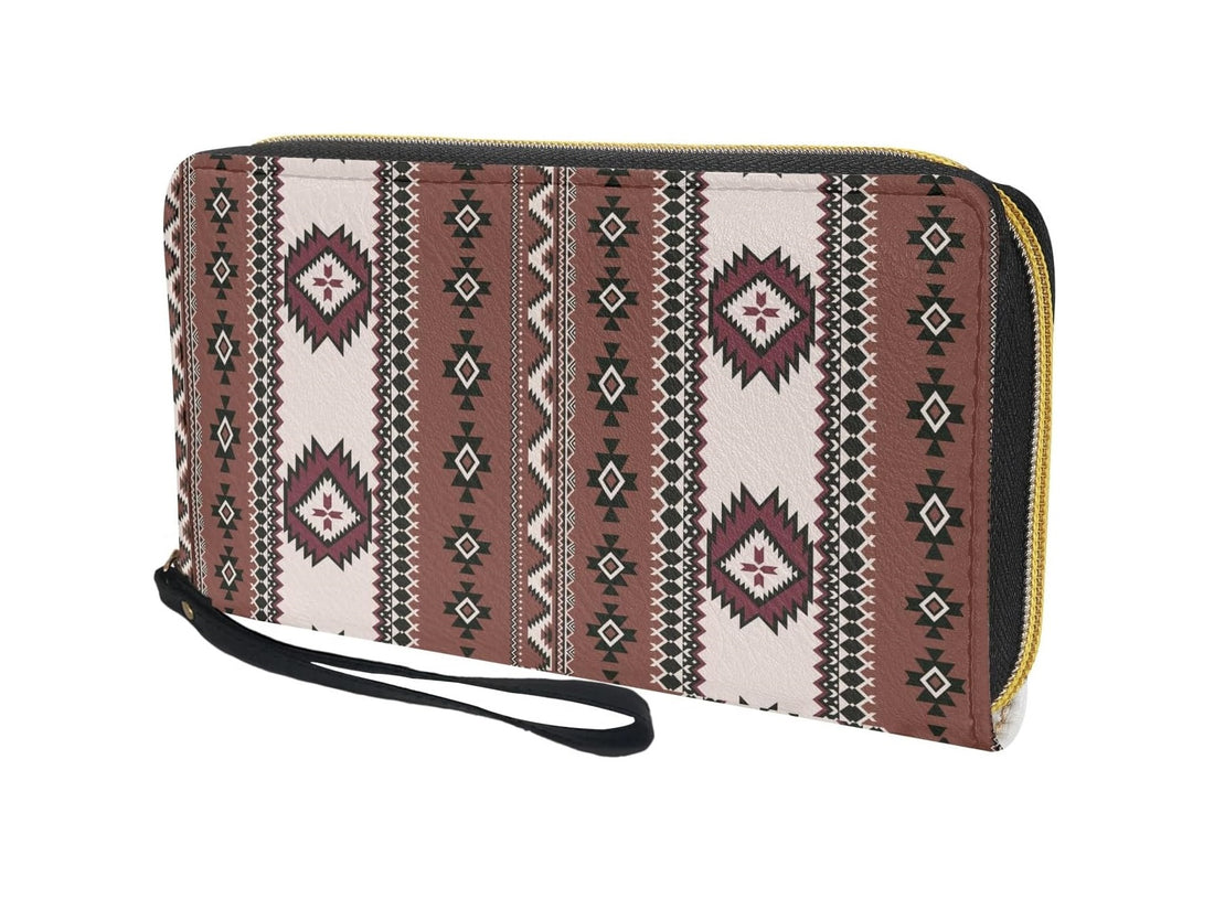 Angled shot of the brown tribal-inspired wristlet wallet showing its textured fabric, gold zipper track, and detachable black wrist strap, highlighting the intricate geometric design.