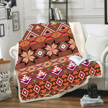 Cozy sherpa blanket with bold Native American geometric tribal patterns in warm brown, orange, and purple hues