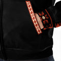 Close-up of fleece jacket pocket featuring traditional red geometric patterns